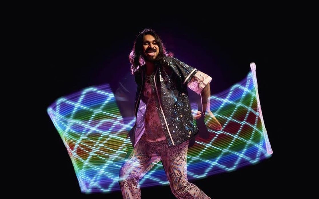 Mustafa flowing with a cool light pattern behind him.